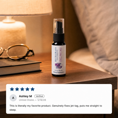 Bluegrass Supplements Drift Away Max sleep spray on a bedside table beside a lamp and glasses, with a five-star customer review shown below.
